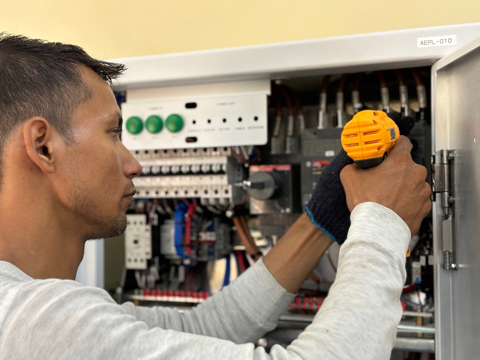 Engineer commissioning a connected electrical control panel on site