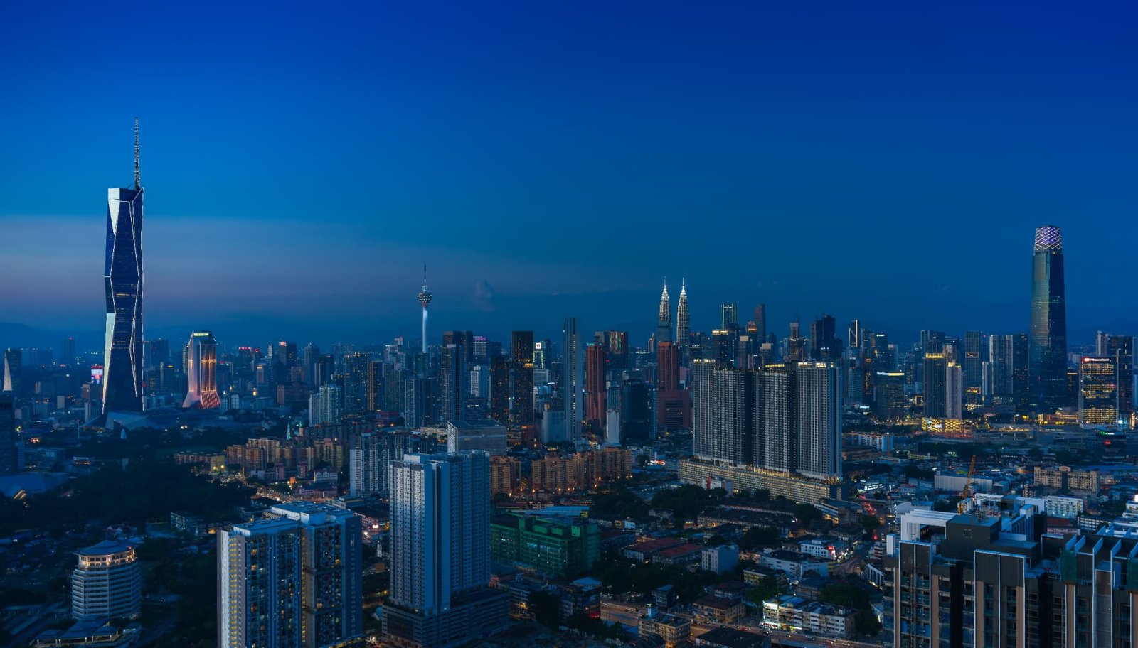 Kuala Lumpur city skyline at dusk with the Petronas Towers and modern skyscrapers
